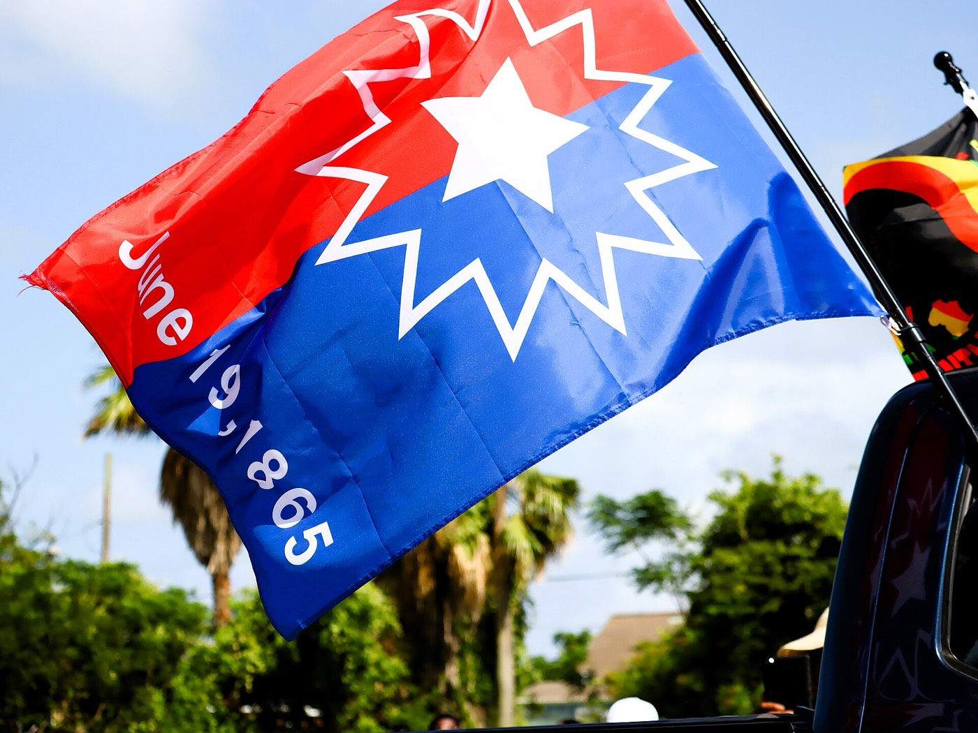 The official Juneteenth flag flying at a Galveston, Texas, parade