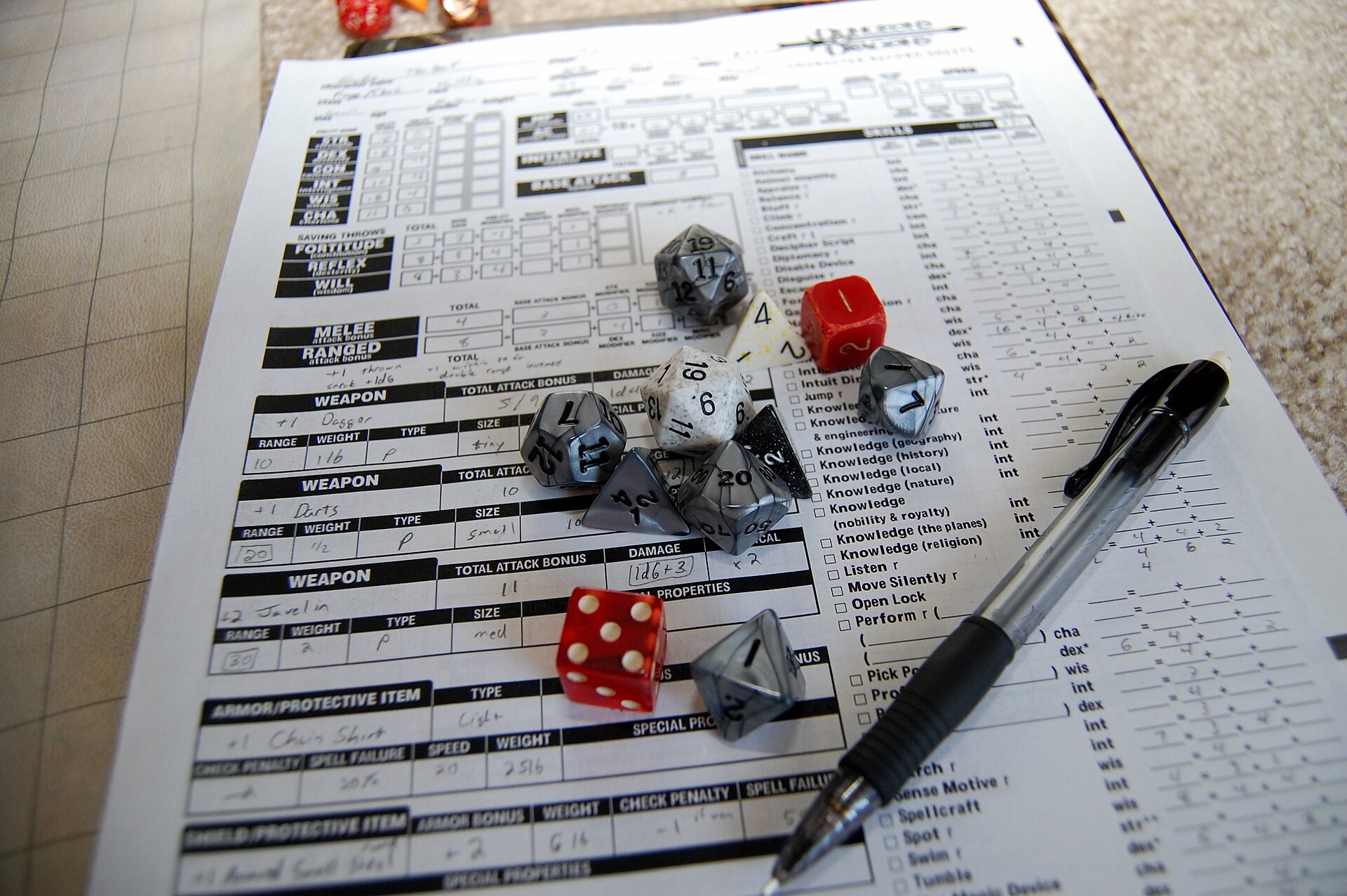 Polyhedral dice on a tabletop role-playing character sheet