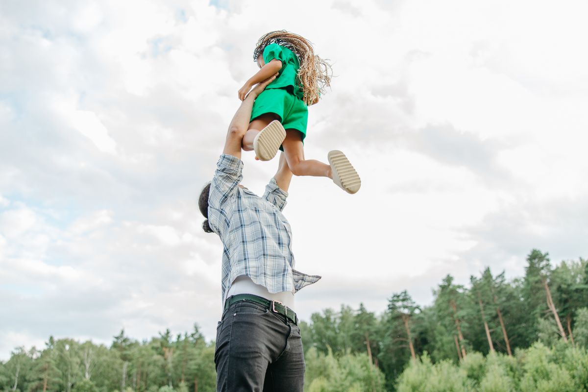 A parent lifts a child skyward